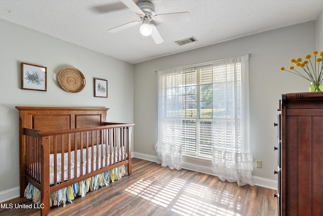 9948 Victor Dr, Olive Branch, MS 38654 - bedroom with baseboards, wood finished floors, a textured ceiling, and a ceiling fan
