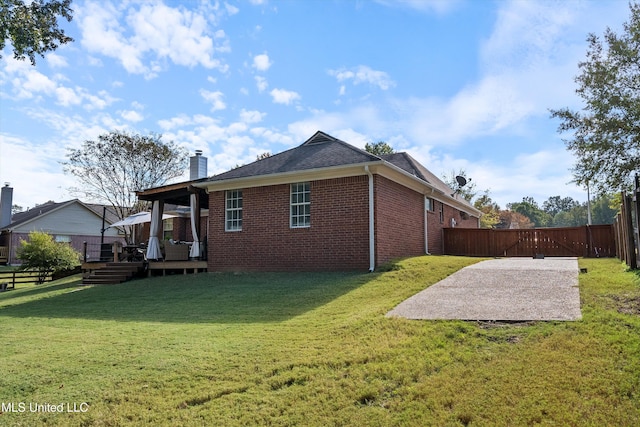 9948 Victor Dr, Olive Branch, MS 38654 - rear view of house featuring brick siding, a chimney, a gate, a wooden deck, and a patio area