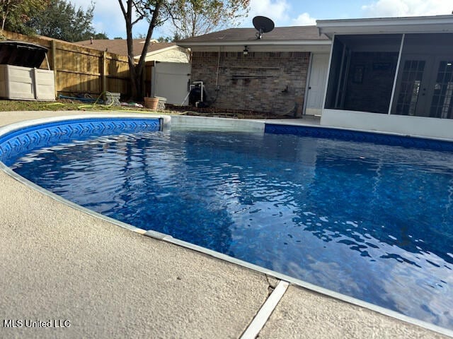 view of swimming pool featuring a sunroom