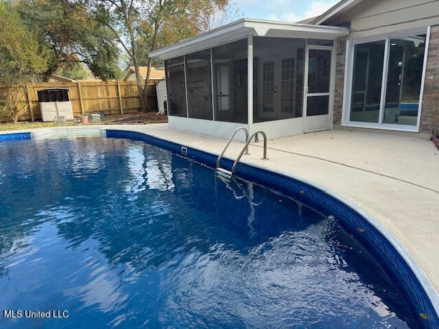 view of pool featuring a sunroom and a patio area