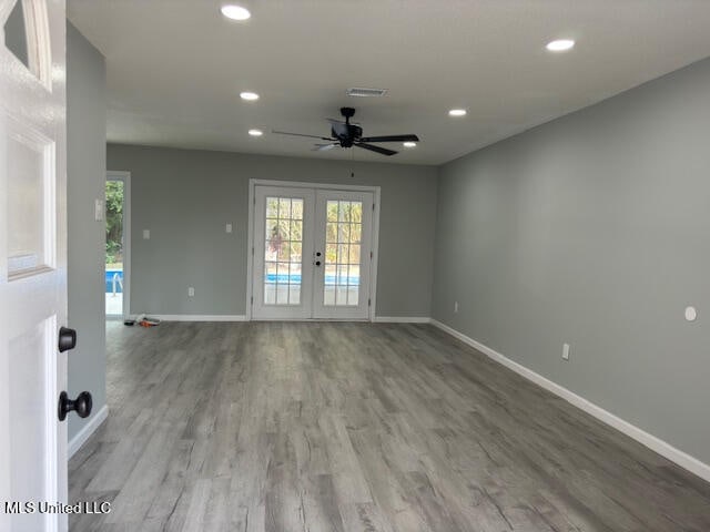 unfurnished room with french doors, ceiling fan, and wood-type flooring