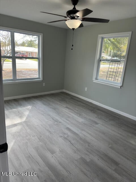 unfurnished room with hardwood / wood-style floors and ceiling fan