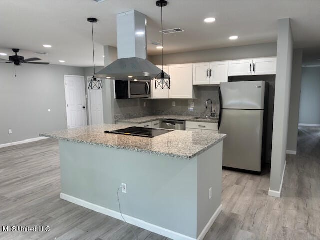 kitchen featuring white cabinetry, sink, appliances with stainless steel finishes, island range hood, and decorative light fixtures