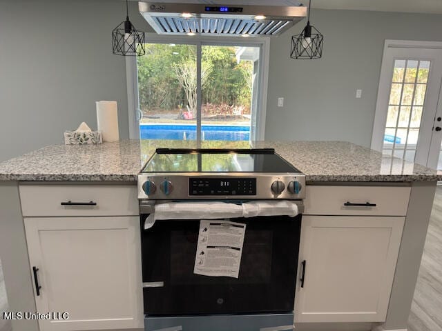 kitchen featuring stainless steel electric range, a healthy amount of sunlight, ventilation hood, and white cabinets