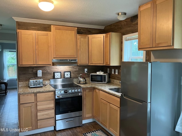 305 S Cleveland Ave, Long Beach, MS 39560 - kitchen with appliances with stainless steel finishes, under cabinet range hood, ornamental molding, healthy amount of natural light, and decorative backsplash