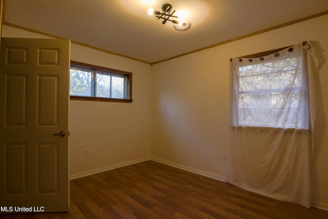 empty room with ornamental molding, dark wood finished floors, and baseboards