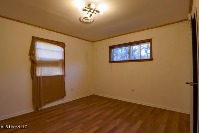 spare room with visible vents, crown molding, baseboards, and wood finished floors