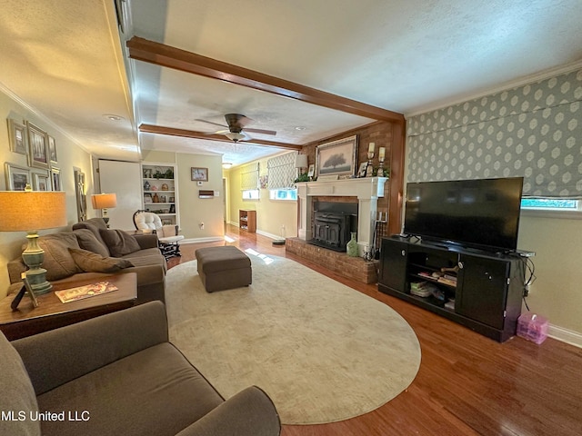 living room featuring built in features, a textured ceiling, ceiling fan, crown molding, and hardwood / wood-style flooring