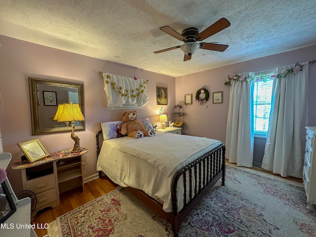 bedroom featuring ceiling fan, a textured ceiling, and hardwood / wood-style floors