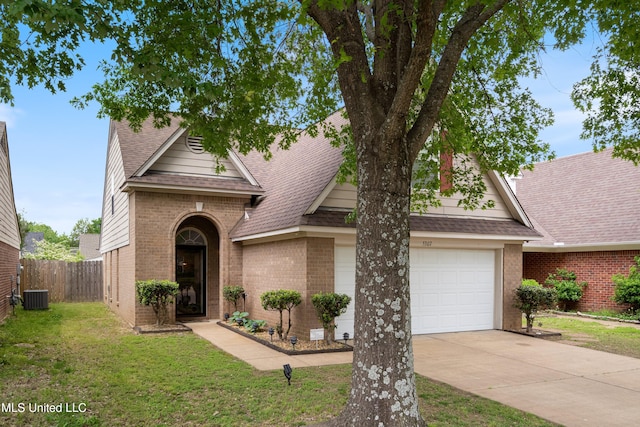 view of front facade featuring fence, a front yard, roof with shingles, brick siding, and driveway
