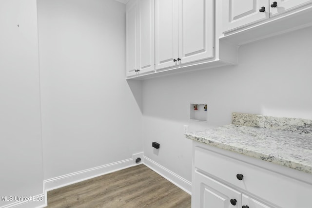 clothes washing area with cabinets, hookup for a washing machine, and hardwood / wood-style floors