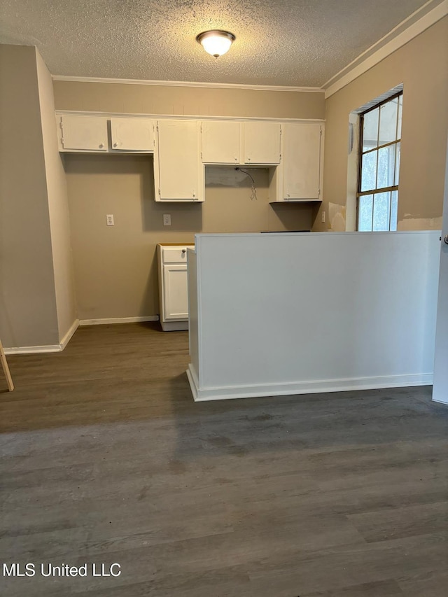 kitchen with a textured ceiling, white cabinets, and dark hardwood / wood-style flooring