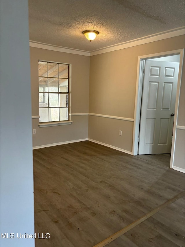 unfurnished room with crown molding, dark wood-type flooring, and a textured ceiling