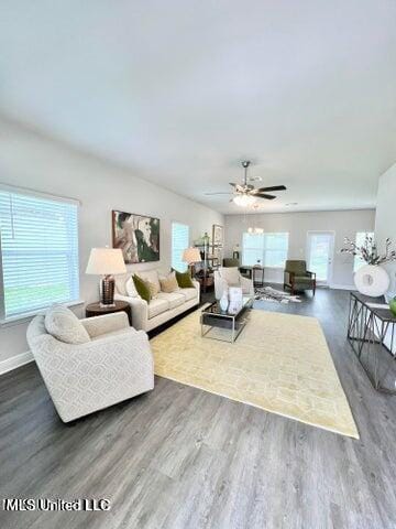 living room with dark hardwood / wood-style flooring and ceiling fan