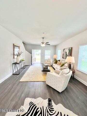 living room featuring dark hardwood / wood-style flooring, ceiling fan, and plenty of natural light