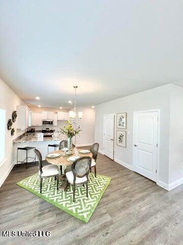 dining room with light hardwood / wood-style flooring and a chandelier