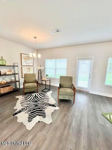 sitting room featuring a chandelier and dark hardwood / wood-style flooring