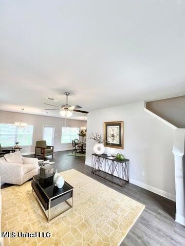 living room featuring hardwood / wood-style floors and ceiling fan with notable chandelier