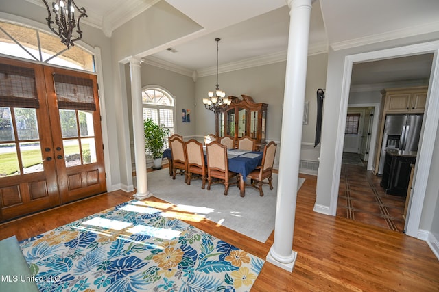 entrance foyer featuring hardwood / wood-style flooring, a chandelier, crown molding, and french doors