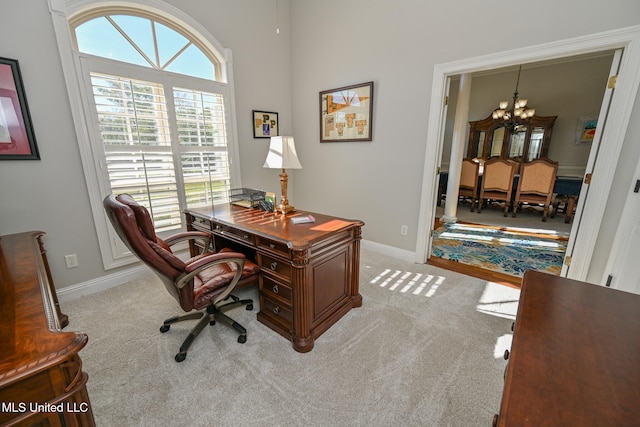 carpeted office with an inviting chandelier