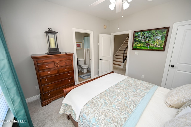 bedroom with ensuite bathroom, light carpet, and ceiling fan