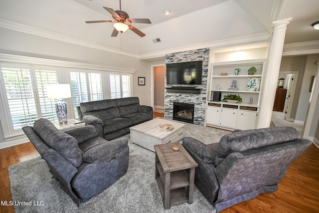 living room with a fireplace, crown molding, dark hardwood / wood-style flooring, decorative columns, and ceiling fan