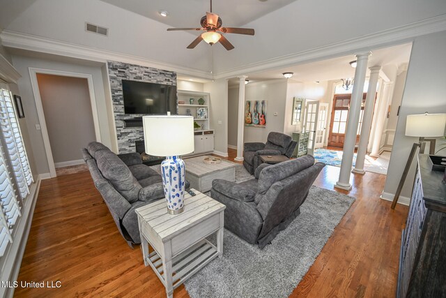 living room with ornate columns, hardwood / wood-style flooring, and crown molding