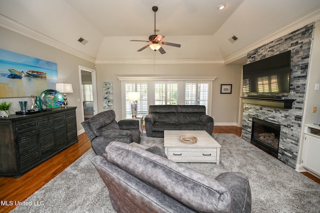 living room with a stone fireplace, dark hardwood / wood-style flooring, crown molding, and vaulted ceiling