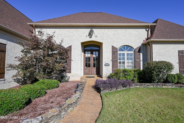 property entrance with a yard and french doors