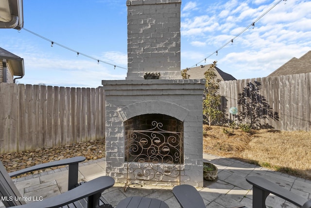 view of patio featuring an outdoor brick fireplace