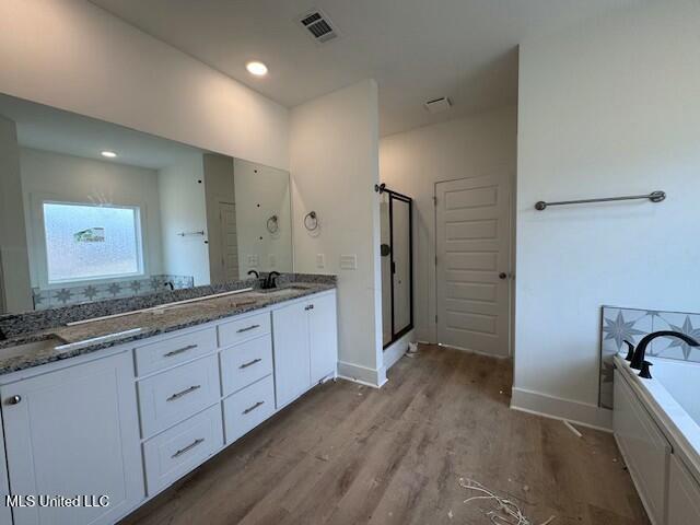 bathroom with shower with separate bathtub, wood-type flooring, and vanity