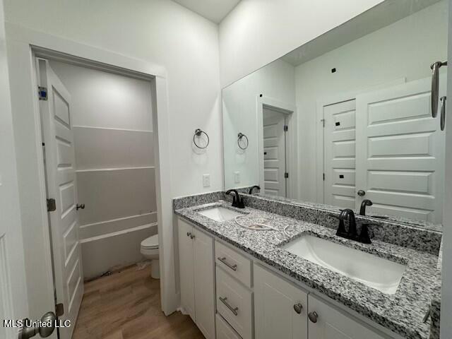 bathroom with toilet, hardwood / wood-style flooring, and vanity