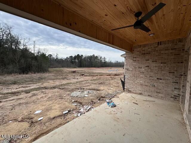 view of yard with ceiling fan and a patio