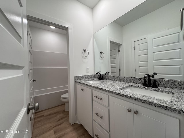 bathroom with hardwood / wood-style flooring, vanity, and toilet