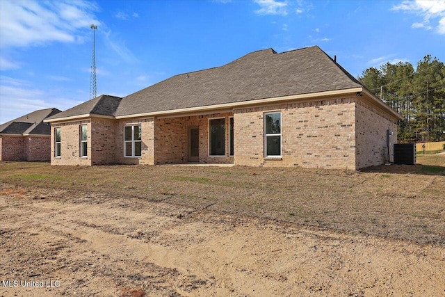 rear view of property with a yard and central air condition unit