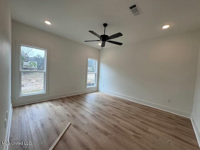 empty room featuring hardwood / wood-style floors and ceiling fan