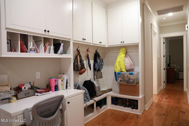 mudroom with light wood finished floors, visible vents, and crown molding