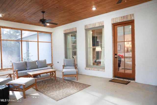 sunroom with wood ceiling and a ceiling fan