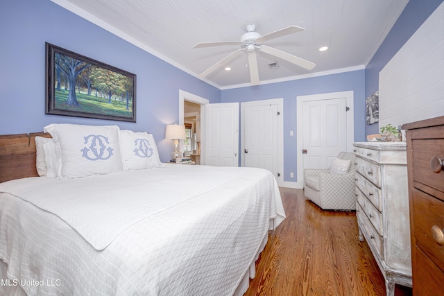 319 Washington Ave, Ocean Springs, MS 39564 - bedroom featuring wood finished floors, two closets, recessed lighting, ceiling fan, and ornamental molding