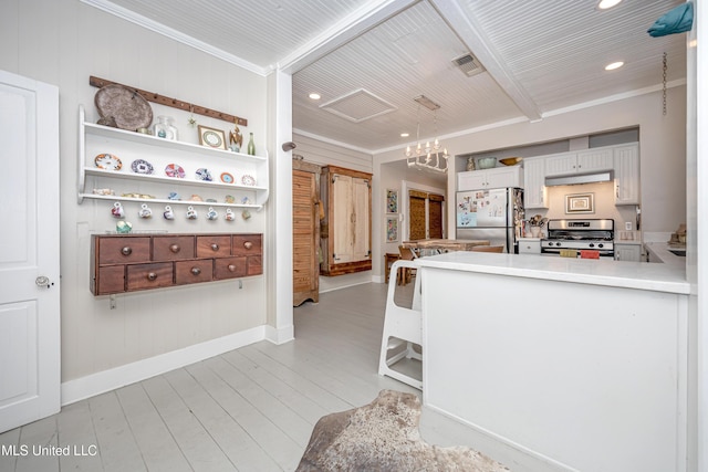 319 Washington Ave, Ocean Springs, MS 39564 - kitchen with appliances with stainless steel finishes, a chandelier, under cabinet range hood, recessed lighting, and light wood-style flooring