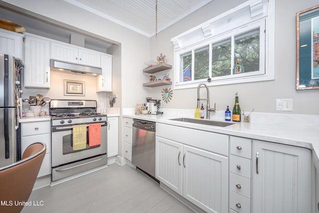 319 Washington Ave, Ocean Springs, MS 39564 - kitchen with appliances with stainless steel finishes, a sink, under cabinet range hood, light countertops, and white cabinetry