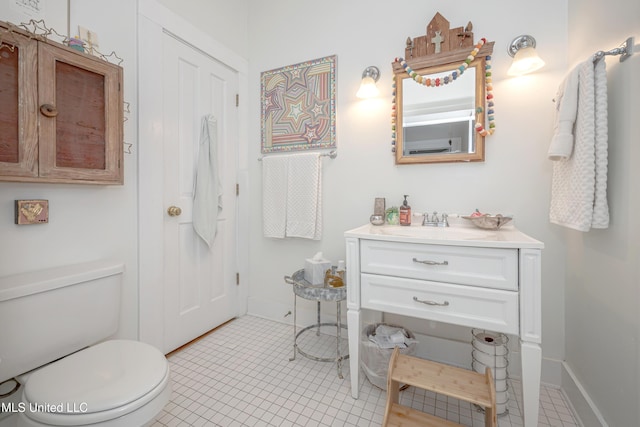 319 Washington Ave, Ocean Springs, MS 39564 - bathroom featuring toilet, vanity, tile patterned flooring, and baseboards