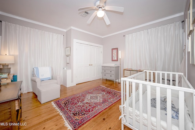319 Washington Ave, Ocean Springs, MS 39564 - bedroom with ornamental molding, a closet, wood finished floors, and a ceiling fan