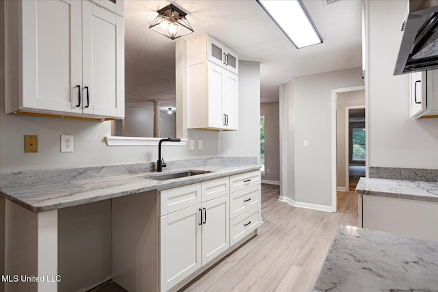 119 Vance Cv, Byhalia, MS 38611 - kitchen with a sink, light wood-type flooring, white cabinets, light stone countertops, and glass insert cabinets