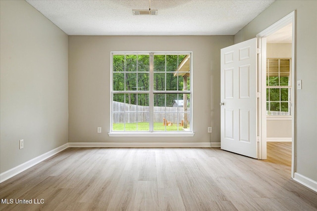 119 Vance Cv, Byhalia, MS 38611 - empty room with wood finished floors, healthy amount of natural light, baseboards, and a textured ceiling