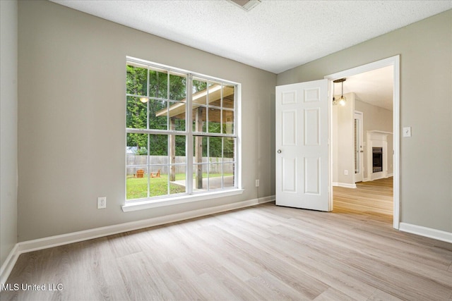 119 Vance Cv, Byhalia, MS 38611 - unfurnished room featuring light wood finished floors, healthy amount of natural light, baseboards, and a textured ceiling