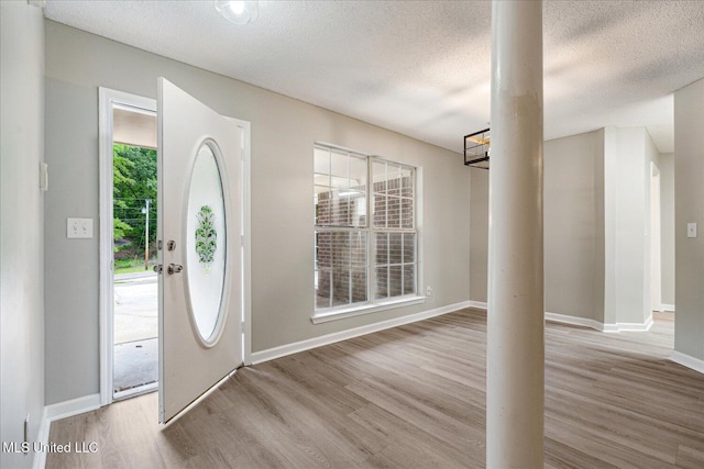 119 Vance Cv, Byhalia, MS 38611 - foyer entrance with wood finished floors, ornate columns, a textured ceiling, and baseboards