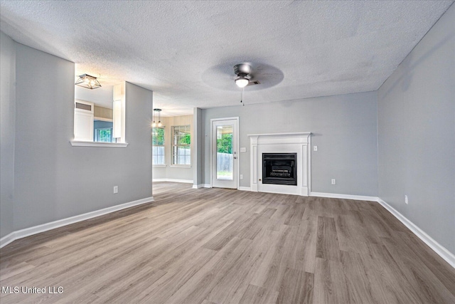 119 Vance Cv, Byhalia, MS 38611 - unfurnished living room featuring a ceiling fan, wood finished floors, a textured ceiling, baseboards, and a fireplace