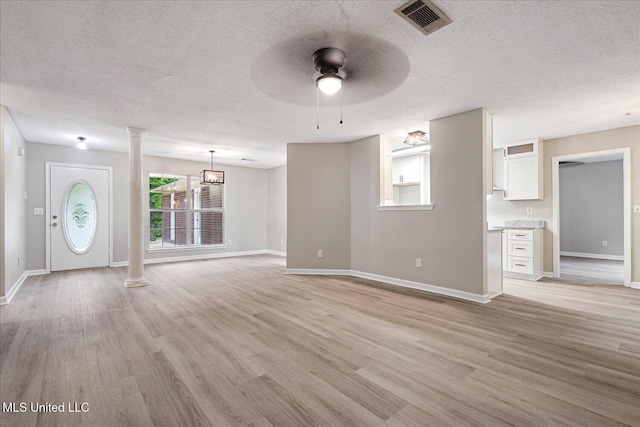 119 Vance Cv, Byhalia, MS 38611 - unfurnished living room featuring ornate columns, a textured ceiling, light wood-type flooring, ceiling fan, and baseboards