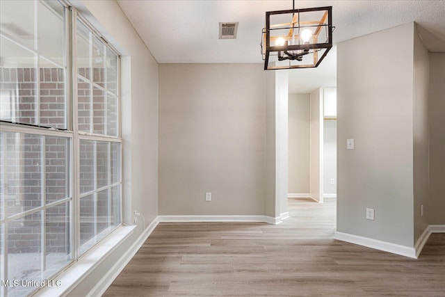 119 Vance Cv, Byhalia, MS 38611 - unfurnished dining area featuring a chandelier, wood finished floors, and baseboards